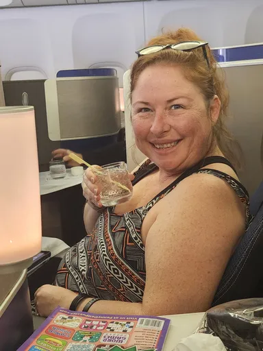 Anna with a cockatil in airplane seat.