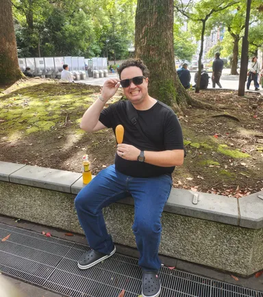 Levi eating a corndog in the park.